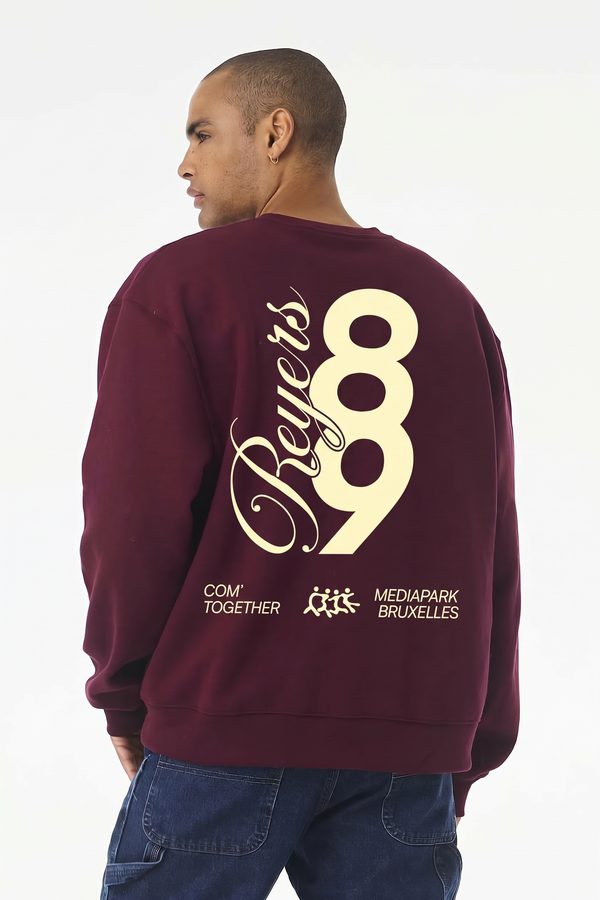 Une personne de dos porte le pull Reyers89, grand 89 et script Reyers imprimés en crème